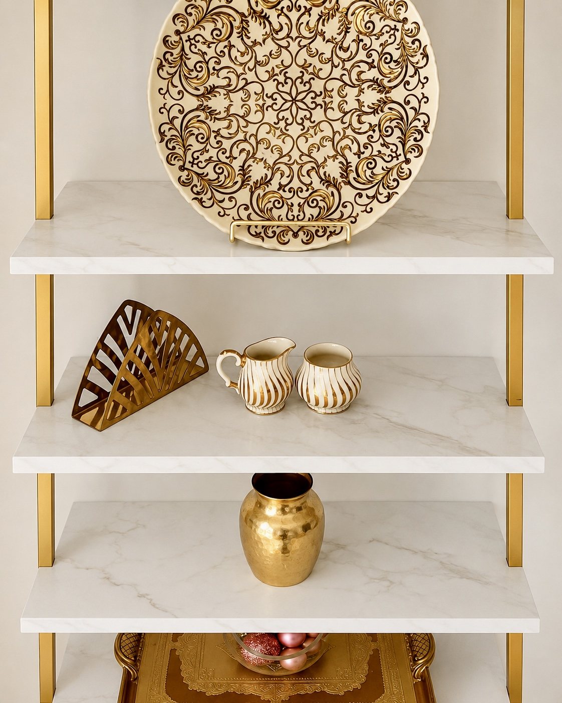 Gold and marble-look shelf styled with decorative plates, vases and accents
