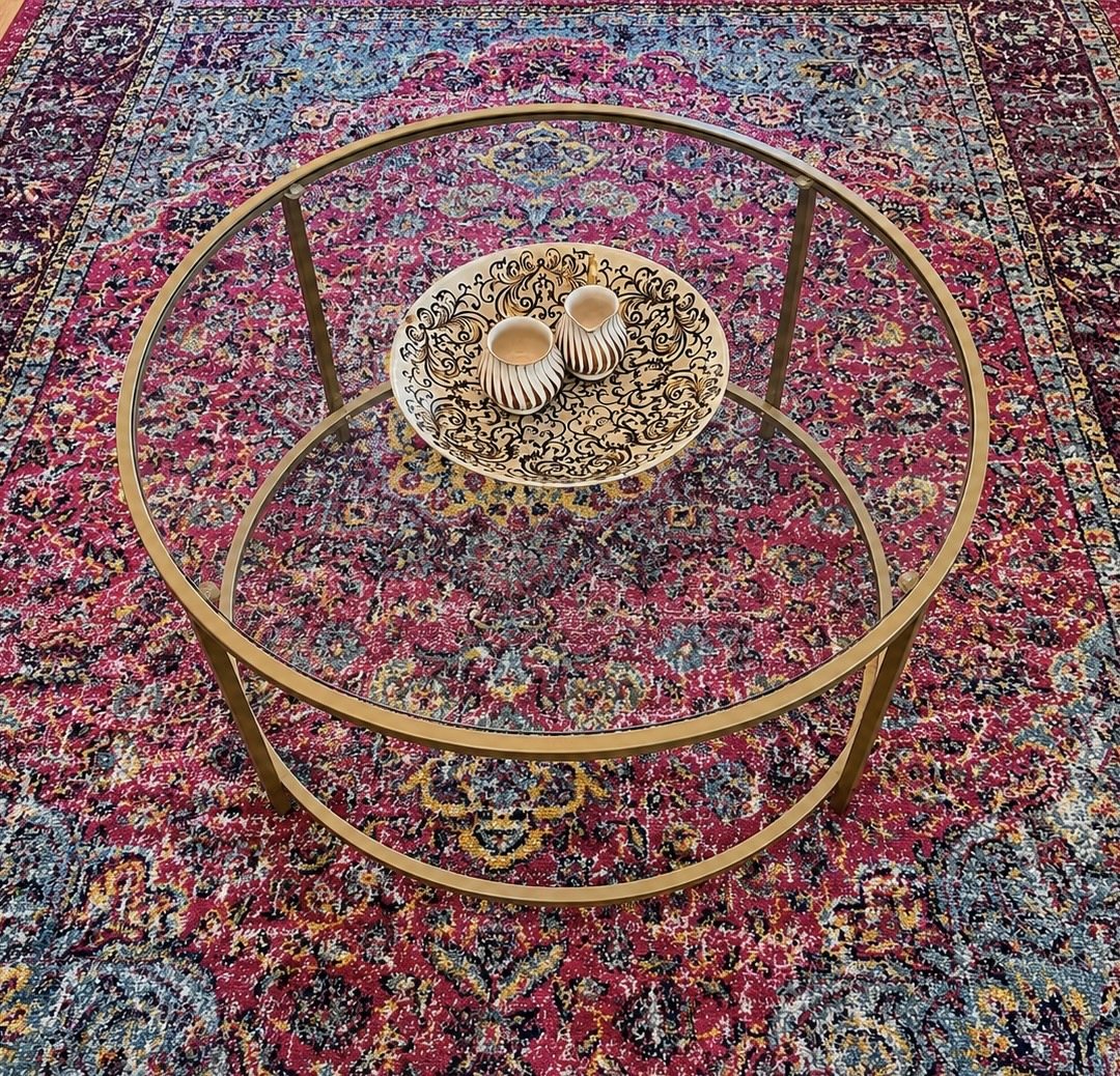Glass and gold coffee table on a colourful vintage-style rug